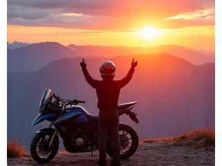Motorcyclist celebrating at a scenic mountain pass after a long ride.